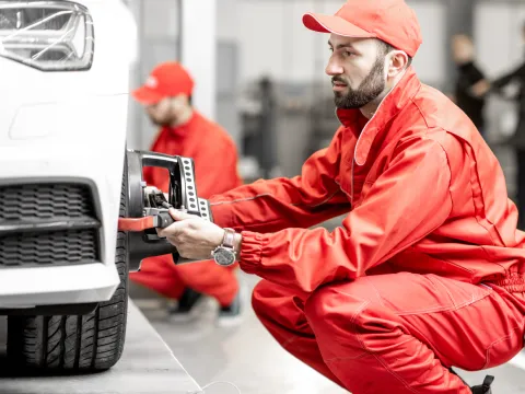 Car mechanic tending to a car